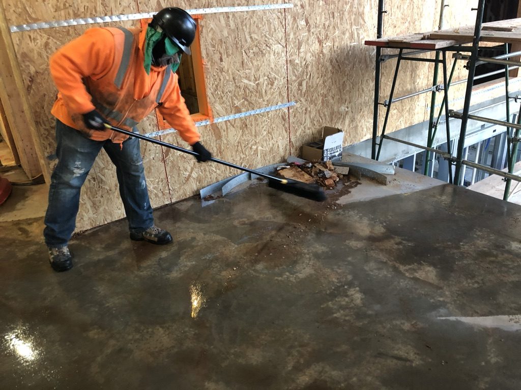 Crew sweeping a construction floor